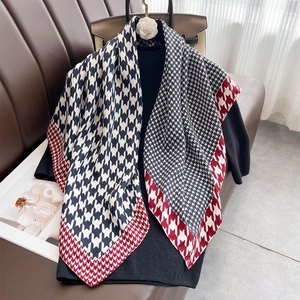 Blue and white houndstooth silk square scarf draped over a black sweater for styling