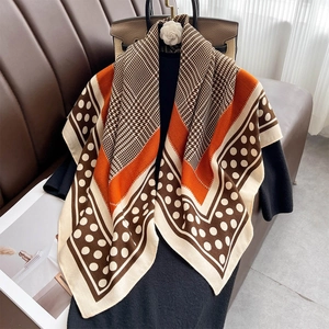 Foulard élégant en soie avec motif pied-de-poule et patchwork orange sur pull noir classique