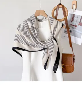 Detail of elegant black and white striped silk scarf with premium stitched edge texture