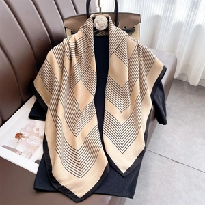 Minimalist striped geometric print silk scarf in beige and black displayed on black clothes