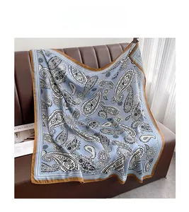 Detailed pattern of foggy blue paisley square scarf with dark brown stitched edges