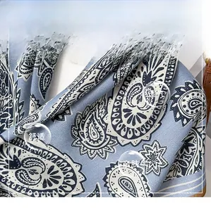 Detail of blue and white paisley silk scarf showing smooth twill weave texture