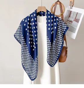 Détail d'un foulard bleu marine à pois blancs assorti à une robe blanche élégante