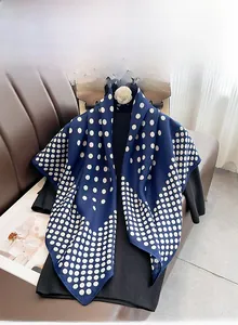 Détail de couture double roulée à la machine sur un foulard en soie à pois bleus