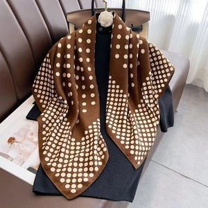 Élégant foulard en soie marron à pois drapé sur un haut en maille noire au style vintage