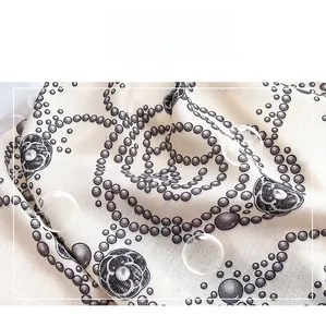 Close-up of rose print silk scarf showing twill texture and smooth glossy fabric