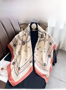 Detailed view of silk scarf with rose print and elegant orange border on black fabric