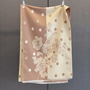 Dettaglio di sciarpa a pois e fiori con design a contrasto e bordi con frange