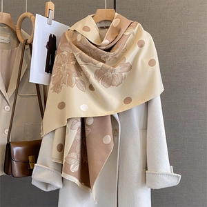 Sciarpa a pois e fiori beige e cammello drappeggiata su un cappotto di lana bianco
