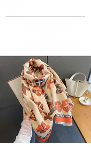 Détail d'une écharpe en cachemire synthétique à imprimé floral et nœuds avec franges