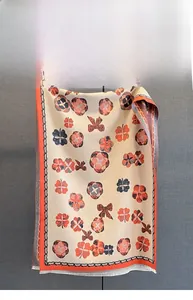 Détail d'une écharpe à imprimé fleuri montrant les motifs fins et les franges blanches