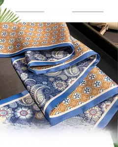 Detail of silk-like scarf featuring dual-sided paisley and geometric diamond patterns