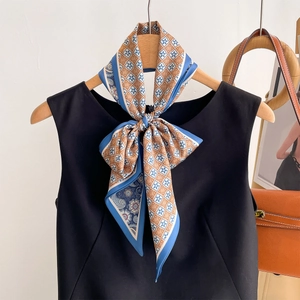 Elegant double-sided floral silk scarf tied on a black top with geometric patterns