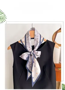 Gros plan d'un élégant foulard en soie à fleurs violettes noué sur un cintre en bois