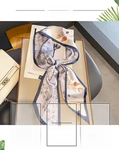 Détails d'un foulard en soie gris-violet avec motifs de feuilles et bordure élégante