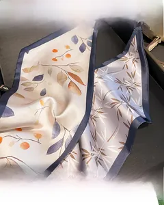 Détail du foulard en soie imprimé avec motif de baies et bordures bleu foncé