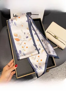 Gros plan détaillé sur l'ourlet fin et le motif de feuilles d'un foulard en satin