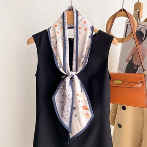 Élégante écharpe étroite en soie à imprimé floral sur robe noire et cintre en bois