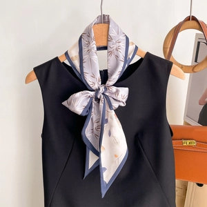 Élégant foulard en soie à fleurs double face noué en nœud sur un haut noir, accessoire