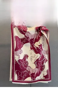 Detail of printed horse pattern on burgundy scarf with fine fringed edges and silky texture
