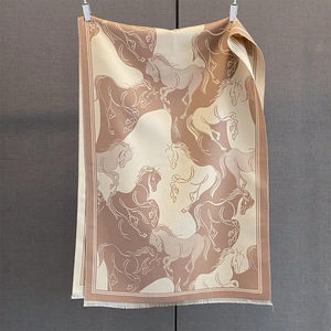 Detail of running horse print on beige scarf with soft white fringe tassels
