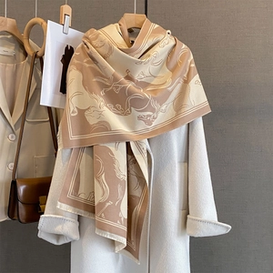 Elegant beige and tan horse print scarf styled with a white coat for winter fashion