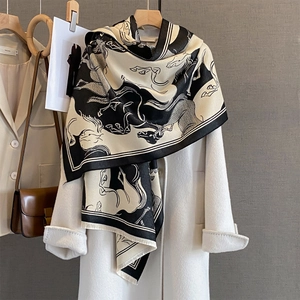 Elegant black and white silk scarf with classic horse print styled on white wool coat