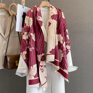 Écharpe vintage à fleurs et rayures bordeaux avec franges sur un manteau blanc