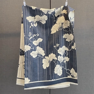 Détail d'une écharpe d'hiver bleu marine avec motif de feuilles et franges