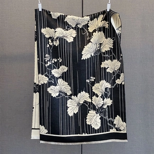 Détail de l'écharpe d'hiver montrant un motif floral noir et blanc et de fines franges