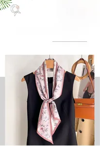 Detailed view of pink floral faux silk skinny scarf tied on a black shirt collar