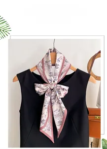 Detail of floral silk scarf tied in a bow showing light pink and purple flower patterns