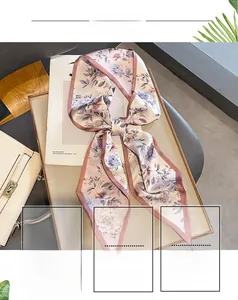 Detailed view of floral silk scarf in pink and purple colors on a luxury gold tray