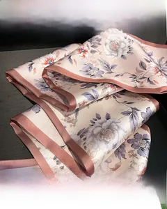 Detailed close-up of double-sided floral pattern on elegant champagne pink silk scarf