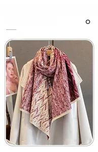 Close-up of geometric cashmere-like scarf with burgundy feather patterns and soft tassels