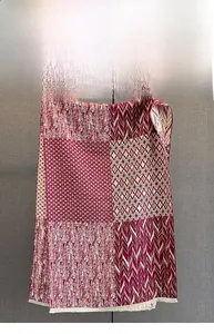 Close-up of geometric texture stitching and fine tassel edges on a warm cashmere scarf