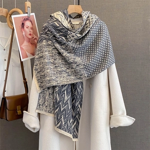 Chic geometric texture cashmere scarf with tassels layered on a white coat