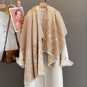 Detailed close-up of earth-toned geometric pattern shawl with fine fringe edges