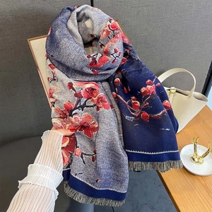 Detailansicht eines Winterschals mit rotem Blumenmuster und weichen Fransen