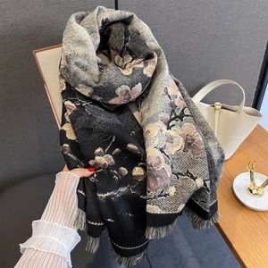 Detailaufnahme der Blumen-Jacquard-Struktur und feinen Fransen am dicken Schal