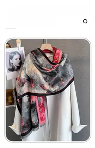 Dettaglio di sciarpa floreale in finto cashmere con nappe su cappotto e gruccia