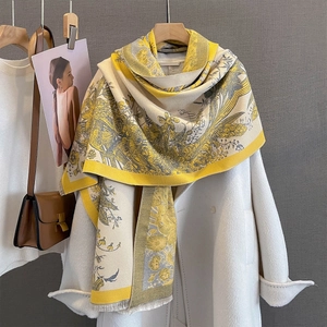 Detail of yellow and beige floral print pashmina with soft fringe on wool coat