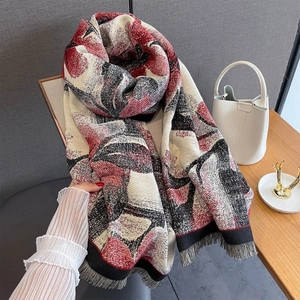 Détail d'un châle floral d'automne à motifs abstraits rouges avec bordures à franges