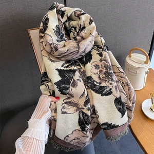 Macro detail of beige cashmere shawl with vintage rose print and elegant tassels