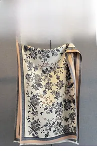 Detail of floral and bird print cashmere-like scarf with soft color and tassels