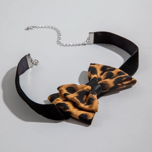 Detail of leopard print bow choker with black velvet ribbon and silver metal clasp
