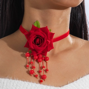 Detailed view of red velvet rose choker with beaded tassels on elegant necklace