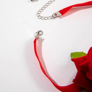 Close-up of a red velvet choker featuring a lobster clasp and adjustable metal chain