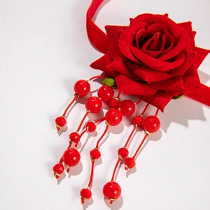 Detailed view of red velvet rose pendant featuring traditional beaded tassels and craftsmanship