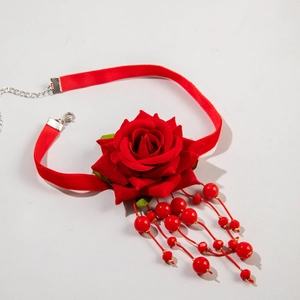 Detail of red velvet choker with fabric rose flower and beaded tassels close-up